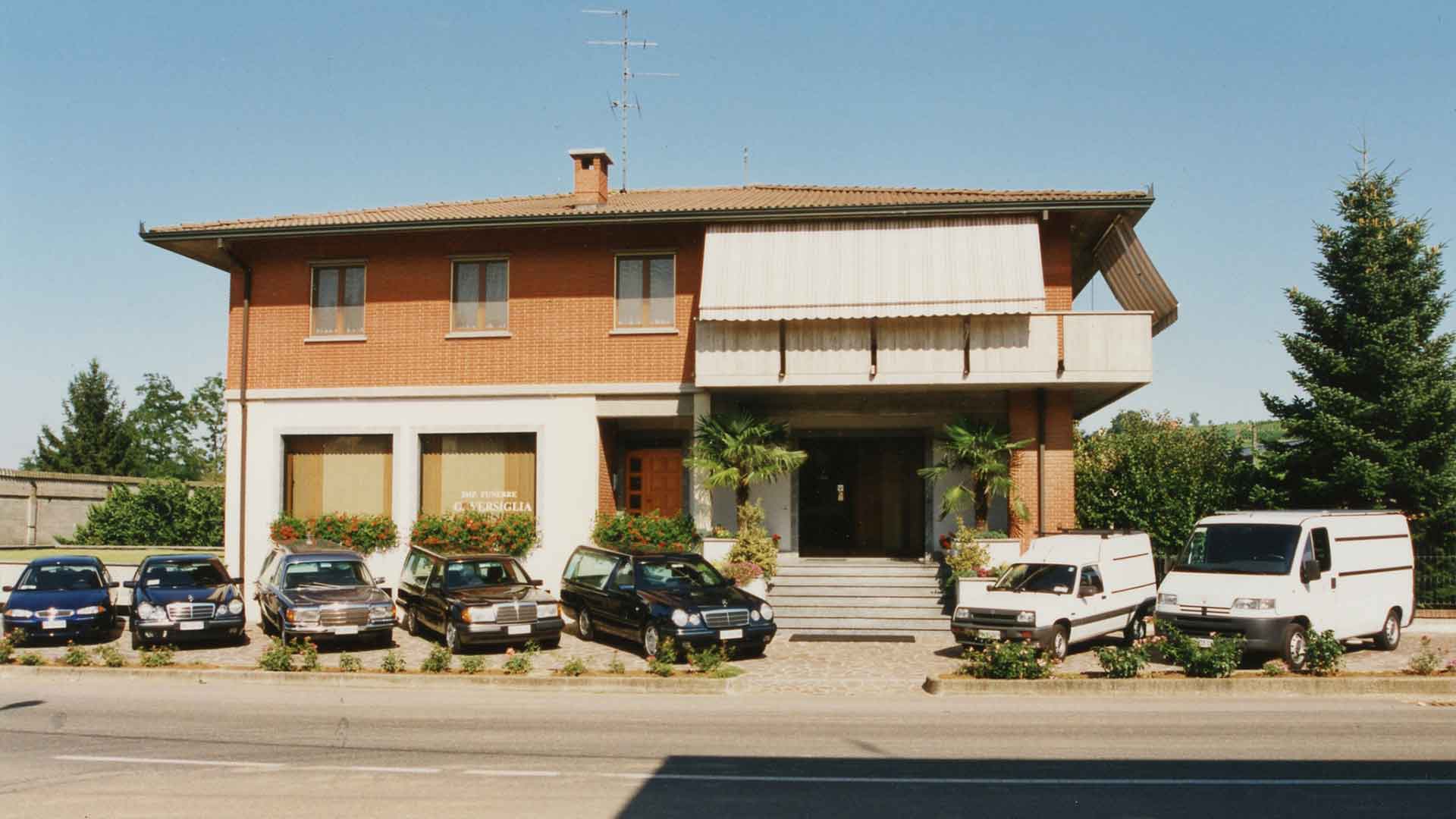 Foto con panoramica esterna di Impresa Versiglia e del parco auto negli anni '90